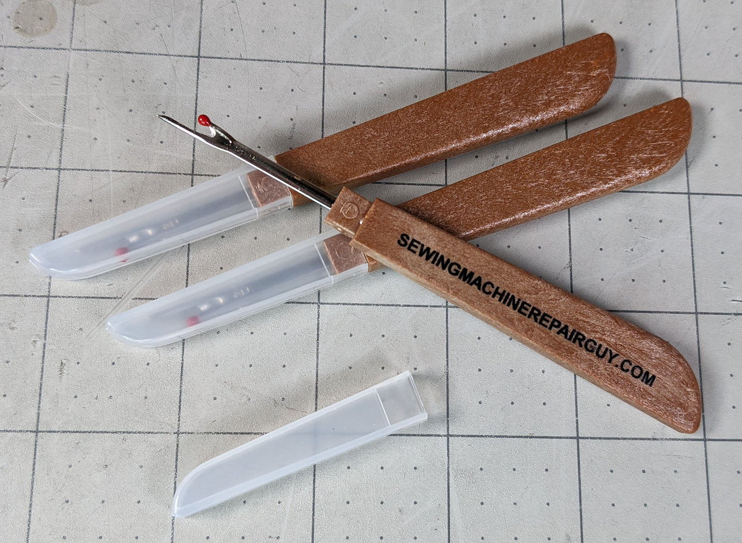 Three seam rippers and one logo sticker for Sewing Machine Repair Guy